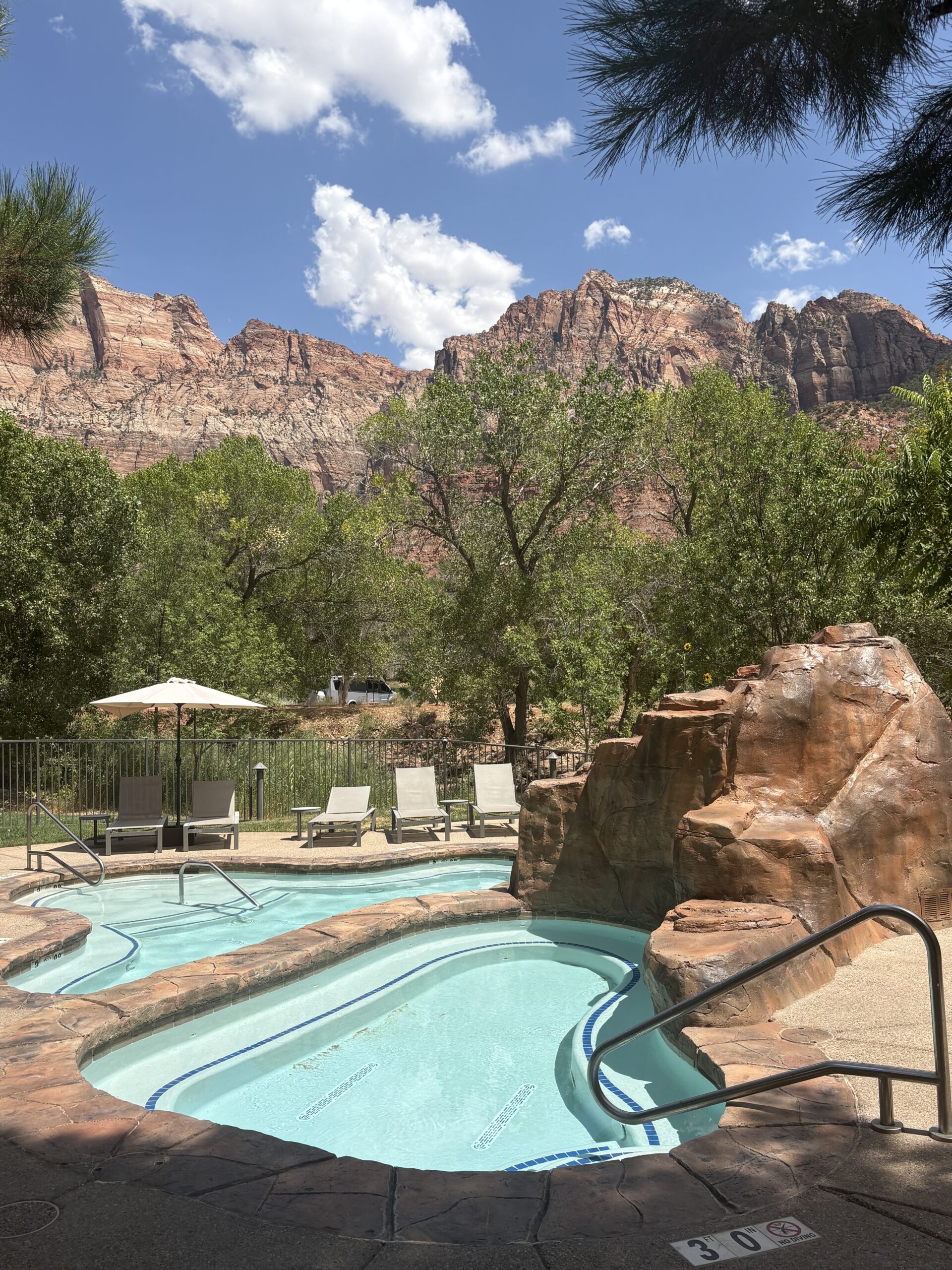 Relaxation Pool at Cliffrose Springdale with organic-shaped rock waterfall and lounge chairs